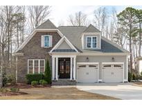 Charming home boasts stone accents, a two-car garage, and a meticulously landscaped front yard at 2826 Walden Rd, Apex, NC 27502