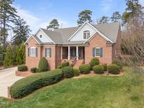 Stunning brick home with well-manicured lawn, blue shutters, and inviting front porch at 3204 Cobblestone Ct, Raleigh, NC 27607