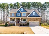 Charming two-story home with stone accents, covered porch, and attached two-car garage at 50 Lockamy Ln, Youngsville, NC 27596
