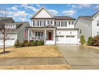 Charming two-story home with white brick, black shutters, a porch and a well-manicured lawn at 562 Boulder Point Dr, Chapel Hill, NC 27516