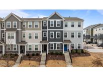 A row of newly constructed townhomes features varied exterior colors, stone accents, and landscaped front yards at 6351 Perry Creek Rd, Raleigh, NC 27616