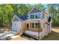 Stunning two-story home featuring a cozy front porch with natural wood posts and a two-car garage at 680 Jasmine Rd, Fuquay Varina, NC 27526