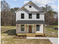 Charming two-story home with a welcoming front porch, board and batten siding and a modern farmhouse design at 1019 Thompson Rd, Four Oaks, NC 27524