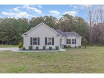 Charming single-story home featuring manicured landscaping, a well-maintained lawn, and a welcoming entrance at 11771 Raleigh Rd, Four Oaks, NC 27524