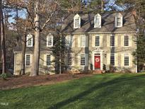 Charming two-story home featuring a red door and mature landscaping at 1305 Bascomb Dr, Raleigh, NC 27614