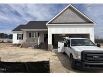 New construction home featuring gray shake shingles, white siding and a Ford work truck in the driveway at 143 Royal Ave, Selma, NC 27576