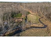 Overhead drone shot of home nestled amidst trees, showcasing proximity to a creek and natural beauty at 3010 University Station Rd, Durham, NC 27705