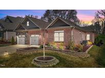 Charming single-Gathering home with a brick exterior, well-maintained lawn, and a two-car garage at 310 Macallan, Burlington, NC 27215