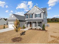 Charming two-story home featuring a gray exterior, black shutters, and a well-manicured lawn at 316 Little Lady Trail, Zebulon, NC 27597