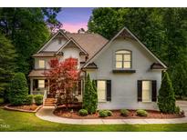 Charming two-story home featuring a lush landscaped yard, brick facade and inviting architectural details at 3421 Griffice Mill Rd, Raleigh, NC 27610
