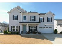 Charming two-story home with a well-manicured lawn, a two-car garage, and a welcoming front porch at 3508 Longleaf Estates Dr, Raleigh, NC 27616