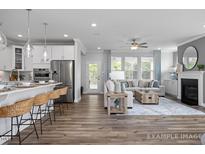 Open-concept living room boasts hardwood floors, lots of natural light, and a cozy fireplace at 4808 Bristol Meadow Dr, Raleigh, NC 27603