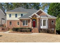 Charming brick-and-siding home featuring an arched doorway and well-manicured landscaping at 509 Edgemore Ave, Cary, NC 27519