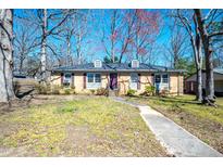 Charming one-story brick home with a walkway leading to the front door and mature trees at 510 Corrida Ave, Durham, NC 27704