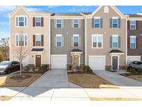 Inviting townhomes with manicured lawns, driveways, and garages for convenient parking at 515 Autumn Cure Ct, Fuquay Varina, NC 27526