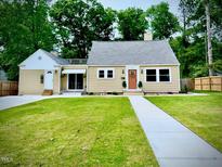 Charming single-story home with a manicured lawn, a walkway, and updated siding and windows at 518 W Chisholm St, Sanford, NC 27330