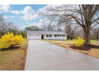 Charming one-story white home with a well-manicured lawn and a long driveway at 546 Hickory Ln, Burlington, NC 27217