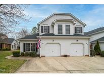 Charming white home with a two-car garage, black shutters, and a well-maintained front yard at 58 Lake Village Drive Dr, Durham, NC 27713
