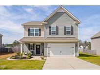 Charming two-story home featuring gray siding, black shutters, a two-car garage, and a well-manicured front yard at 606 Marian Way, Sanford, NC 27330