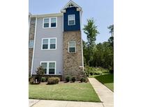 Two-story townhouse with a blend of brick and siding, complemented by a well-manicured lawn and sidewalk at 730 Firebrick Drive Dr, Cary, NC 27519