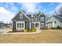 Charming two-story home showcasing its unique exterior features, detailed trim, and well-manicured landscaping at 8201 Southmoor Hill Trl, Wake Forest, NC 27587