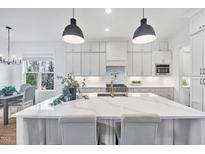Bright kitchen boasts a large island with quartz countertops and stainless steel appliances at 8201 Southmoor Hill Trl, Wake Forest, NC 27587