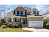Charming two-story home featuring a stone and siding exterior, well-manicured landscaping, and an attached two-car garage at 9117 Cornwell Dr, Wake Forest, NC 27587