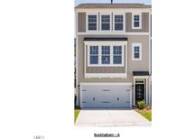 Charming townhouse featuring neutral siding, a two-car garage, and classic architectural details at 10004 Secluded Garden Drive Rd # 180, Apex, NC 27523