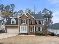 Beautiful two-story brick home with attached two car garage and well maintained lawn and landscaping at 102 Caymus Ct, Cary, NC 27519