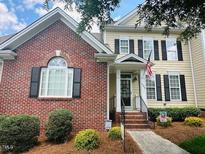 Charming home featuring a brick facade and a welcoming front porch with an American flag displayed at 1203 Fairview Club Dr, Wake Forest, NC 27587