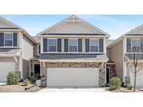 Charming two-story townhome featuring a two-car garage, brick accents and dark shutters at 131 Explorer Dr # 257, Morrisville, NC 27560