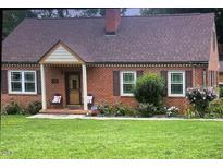 Charming brick home with a cozy front porch, well-manicured lawn, and mature landscaping at 132 Lord Ashley Rd, Raleigh, NC 27610