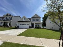 Charming two-story home featuring a well-manicured lawn and a spacious two-car garage at 1560 Bright Coral Trl, Wendell, NC 27591