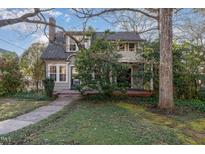 Charming two-story home featuring a covered front porch and landscaped yard at 2122 Woodland Ave, Raleigh, NC 27608