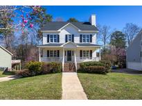 Charming two-story home with a welcoming front porch, classic black shutters, and landscaped front yard at 213 Yellow Poplar Ave, Wake Forest, NC 27587