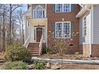 Charming brick home featuring a welcoming front entrance with well-maintained landscaping and stylish front door at 2325 Old Oak Pl, Hillsborough, NC 27278