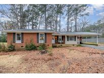 Charming brick ranch home with a covered carport and mature trees surrounding the property at 2968 Tram Rd, Fuquay Varina, NC 27526