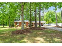Charming single-story brick home with mature trees in front yard at 2968 Tram Rd, Fuquay Varina, NC 27526