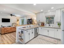 Bright kitchen features white cabinets, tile backsplash, and stylish countertop, seamlessly connecting to the cozy living space at 2968 Tram Rd, Fuquay Varina, NC 27526