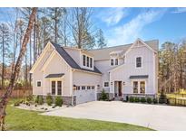 Inviting two-story home boasts a manicured lawn, light grey siding, and an attached two-car garage at 298 Bonterra Way, Chapel Hill, NC 27516