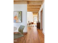 Inviting living room boasts exposed wood beams, hardwood floors, and view to a sunlit seating area at 380 Wesley Ct, Chapel Hill, NC 27516