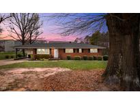 Charming brick home featuring a well-maintained lawn and established landscaping at 3904 Cash Rd, Durham, NC 27703