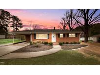 Charming brick home with well-maintained landscaping, covered parking, and a welcoming front entrance at 3908 Cash Rd, Durham, NC 27703