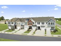 Attractive row of townhomes, each with a one car garage and driveway, set against a blue sky at 40 Hyacinth Ln # 95, Angier, NC 27501
