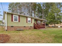 Charming single-story home featuring a covered front porch with red shutters and brick foundation at 402 Abbott Dr, Sanford, NC 27330