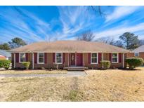 Charming one-story brick home featuring red shutters and a well-maintained front lawn at 5304 Partridge St, Durham, NC 27704
