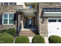 Inviting front entrance with stone facade, brick steps, and a welcoming 'Welcome' sign at 5421 Downton Grove Ct, Fuquay Varina, NC 27526