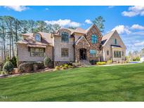 Stunning brick home boasts mature landscaping and architectural details under a clear sky at 1001 Welch Ln, Raleigh, NC 27614