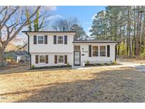 Charming two-story home featuring a white facade, contrasting shutters, and a well-maintained front yard at 1004 Helms Pl, Raleigh, NC 27610