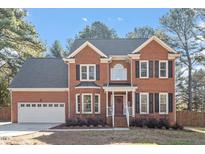 Charming two-story brick home with attached garage and manicured front lawn at 101 Weatherly Pl, Cary, NC 27518
